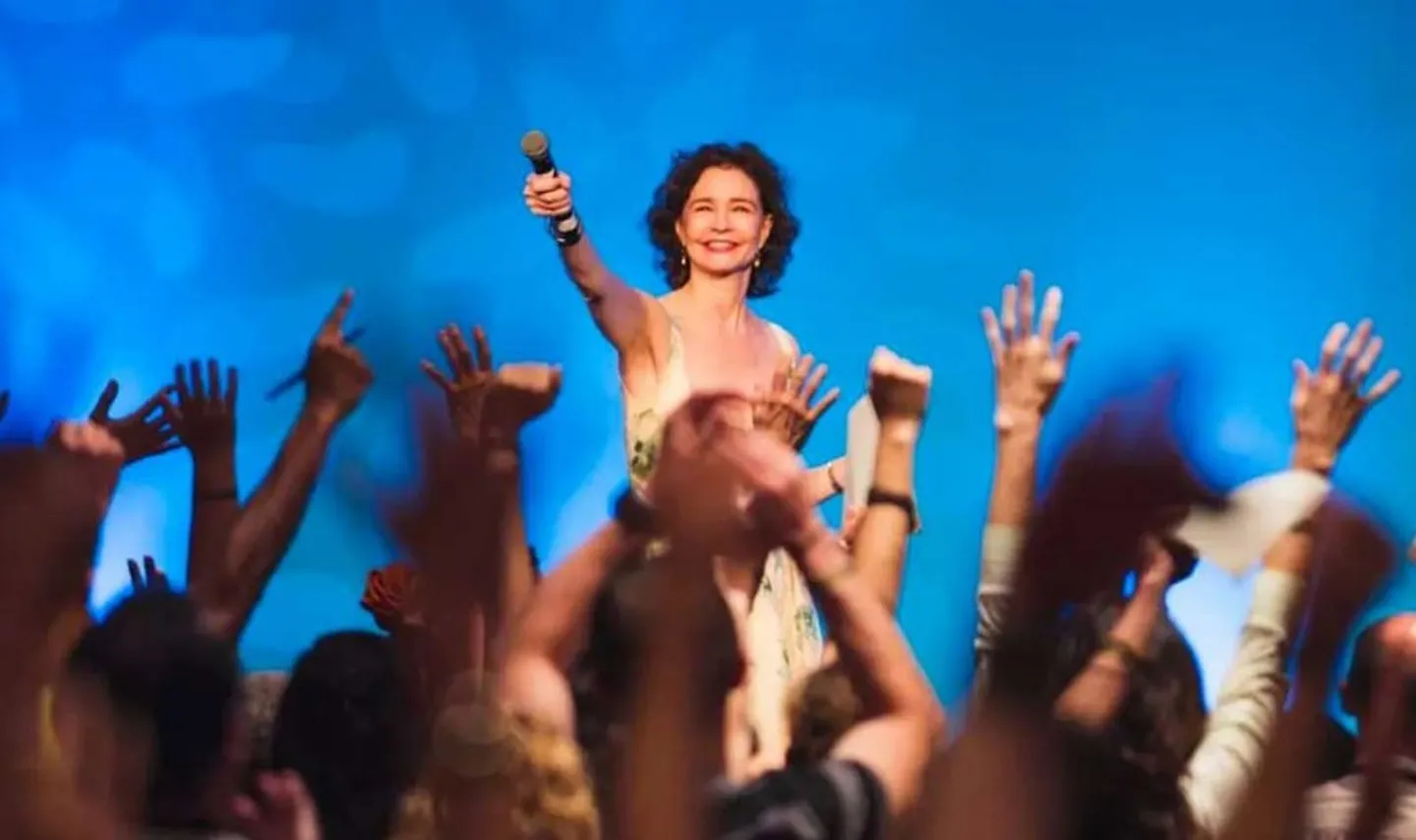 Sonia Choquette on stage, mic raised, in front of a cheering audience