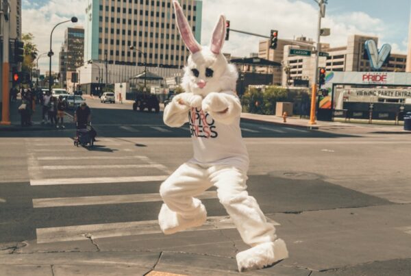 person in rabbit mascot jumping near road side